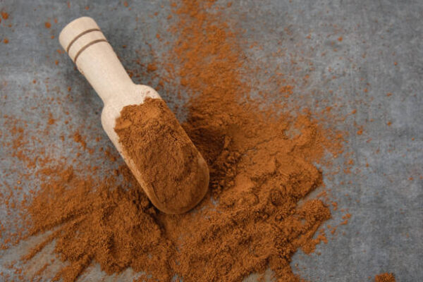 Kayu manis bubuk or cinnamon powder on wooden spoon