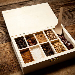 Assortment of spices in wooden box on old wooden table